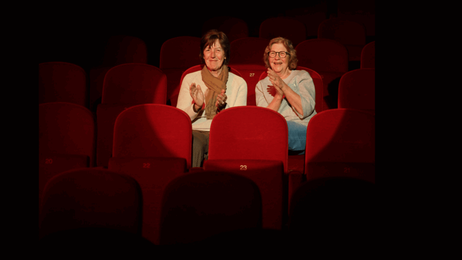 twee bezoekers in de spotlight geven een applaus