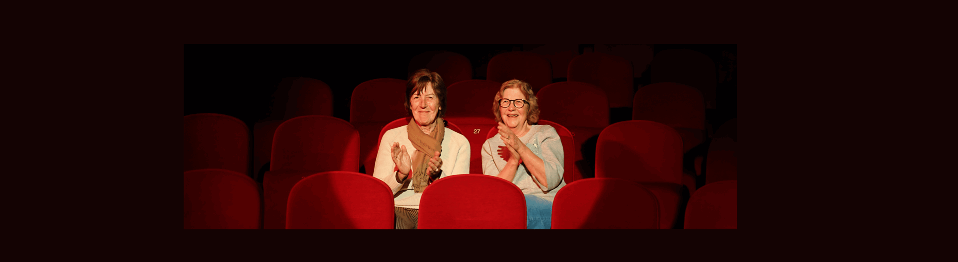 twee bezoekers in de spotlight geven een applaus