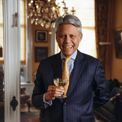 man in pak met glas wijn lacht