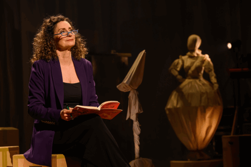 Pia zit op een doos met een boekje in haar hand