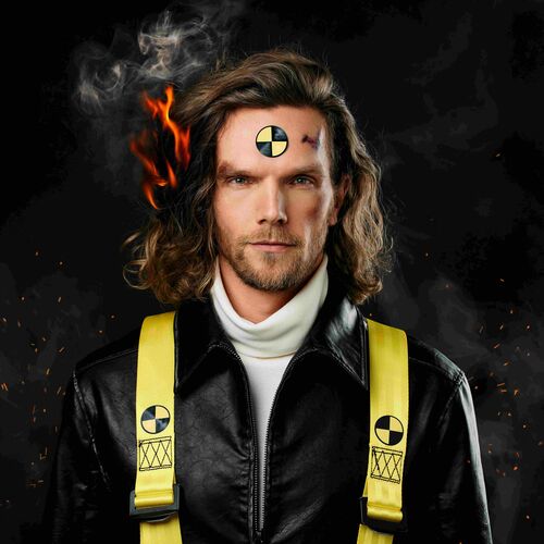 Man met lang, golvend haar en een crash-test symbool op zijn voorhoofd, gekleed in een zwart leren jack en gele veiligheidsriemen.