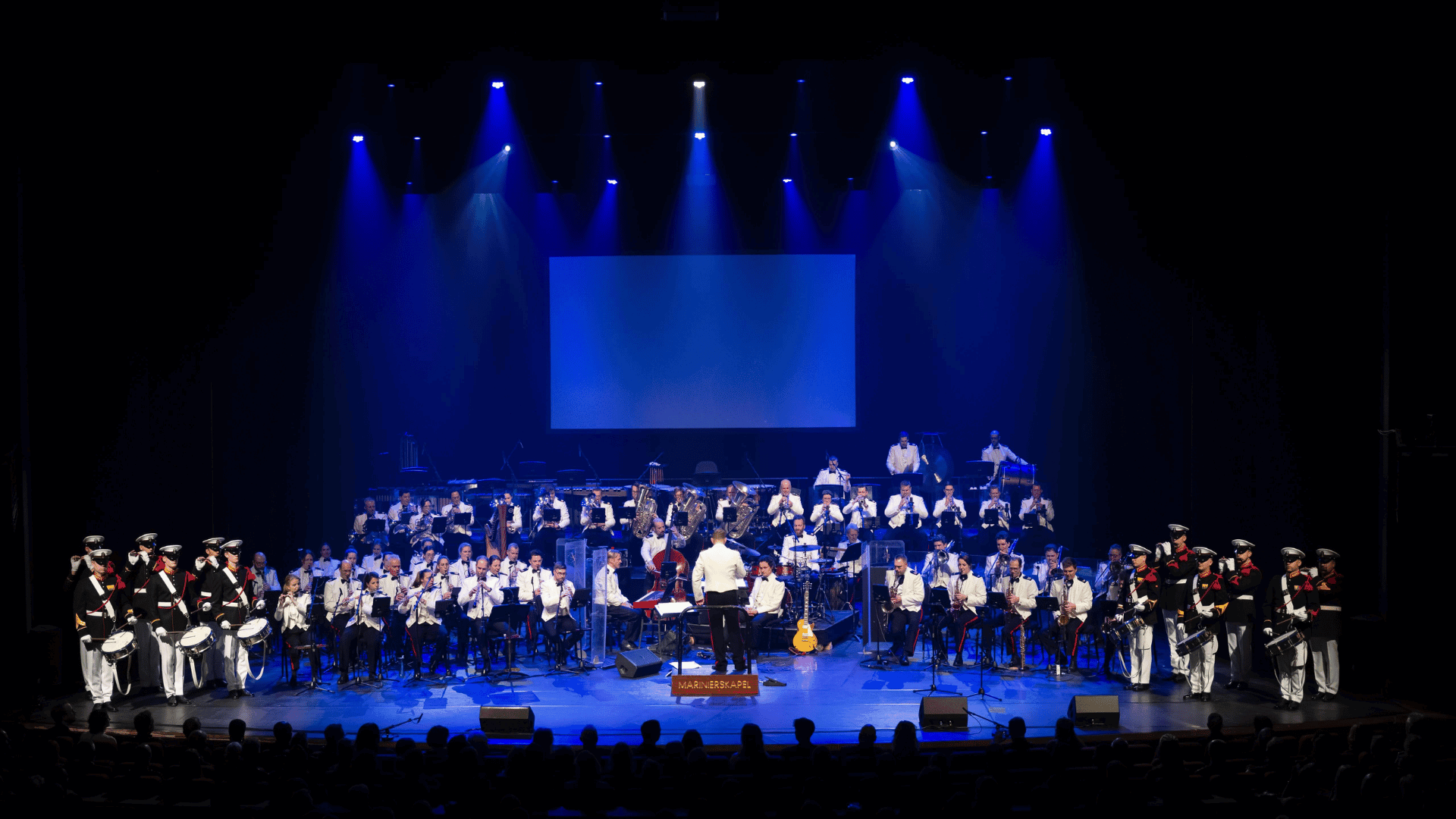 marinierskapel op het podium in blauwe spotlights